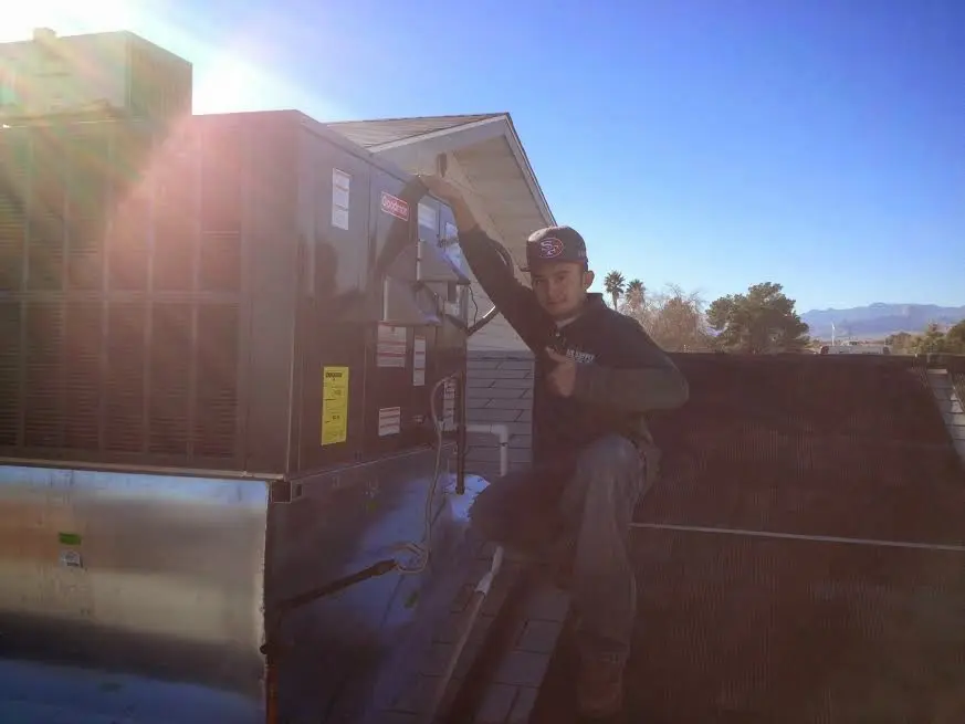 HVAC technician performing HVAC Inspection on a rooftop unit in Kingsford